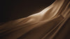 Champagne silk chiffon moving in slow motion against a dark background